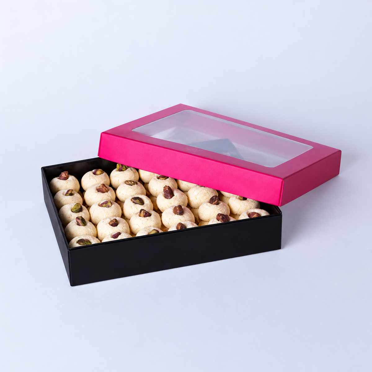 Douaihy Ghoraybeh ~ 65pcs. Pistachio-topped shortbread cookies in a black box with pink windowed lid.