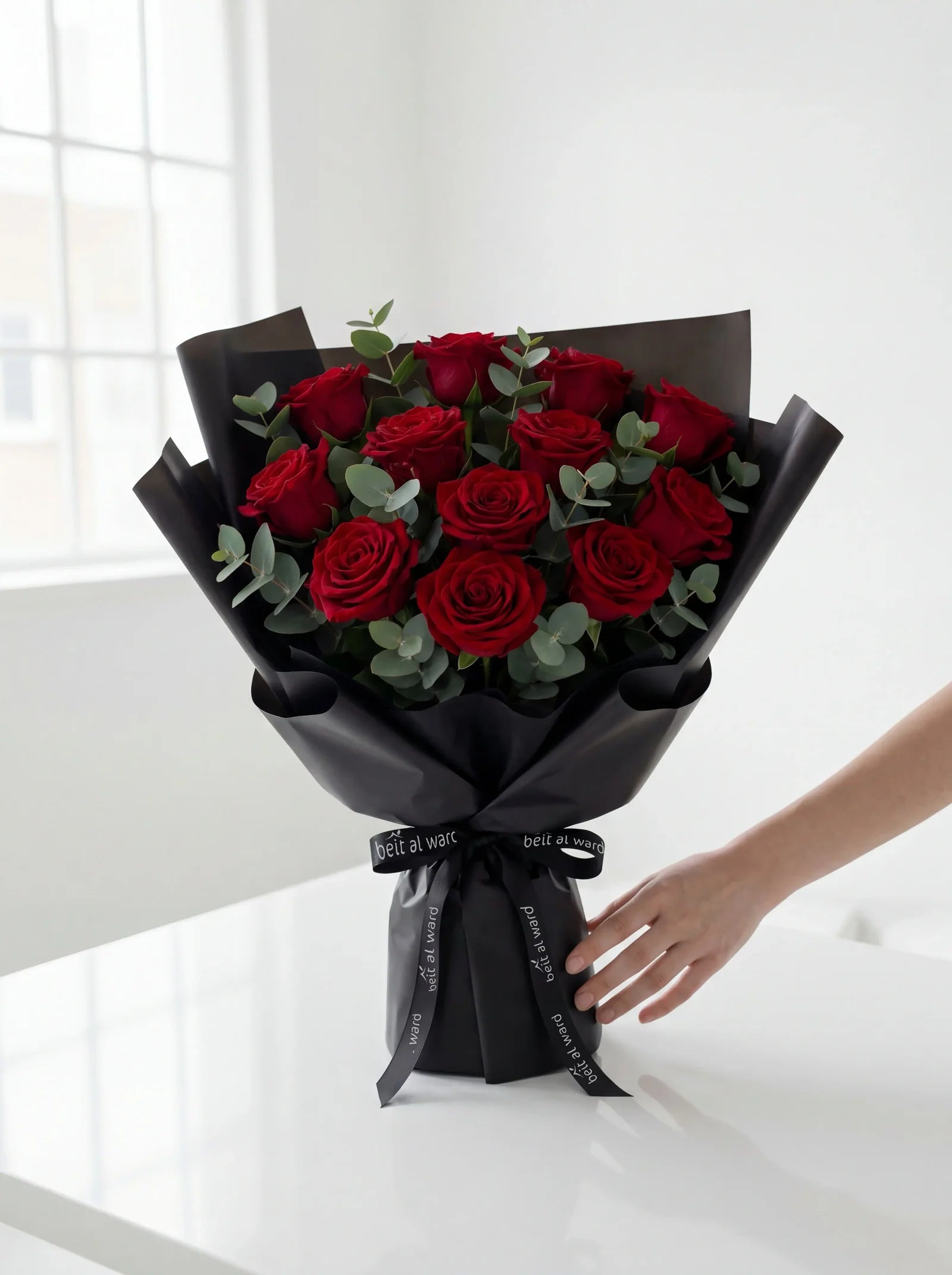 Red roses bouquet wrapped in black paper for romantic gifting in Lebanon by Beit El Ward