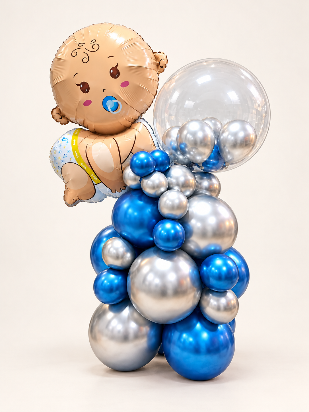 بالون فويل Little Prince للمولود الصبي مع لهاية زرقاء بجانب فقاعة شفافة مليئة ببالونات زرقاء وفضية فوق قاعدة بالونات معدنية زرقاء وفضية