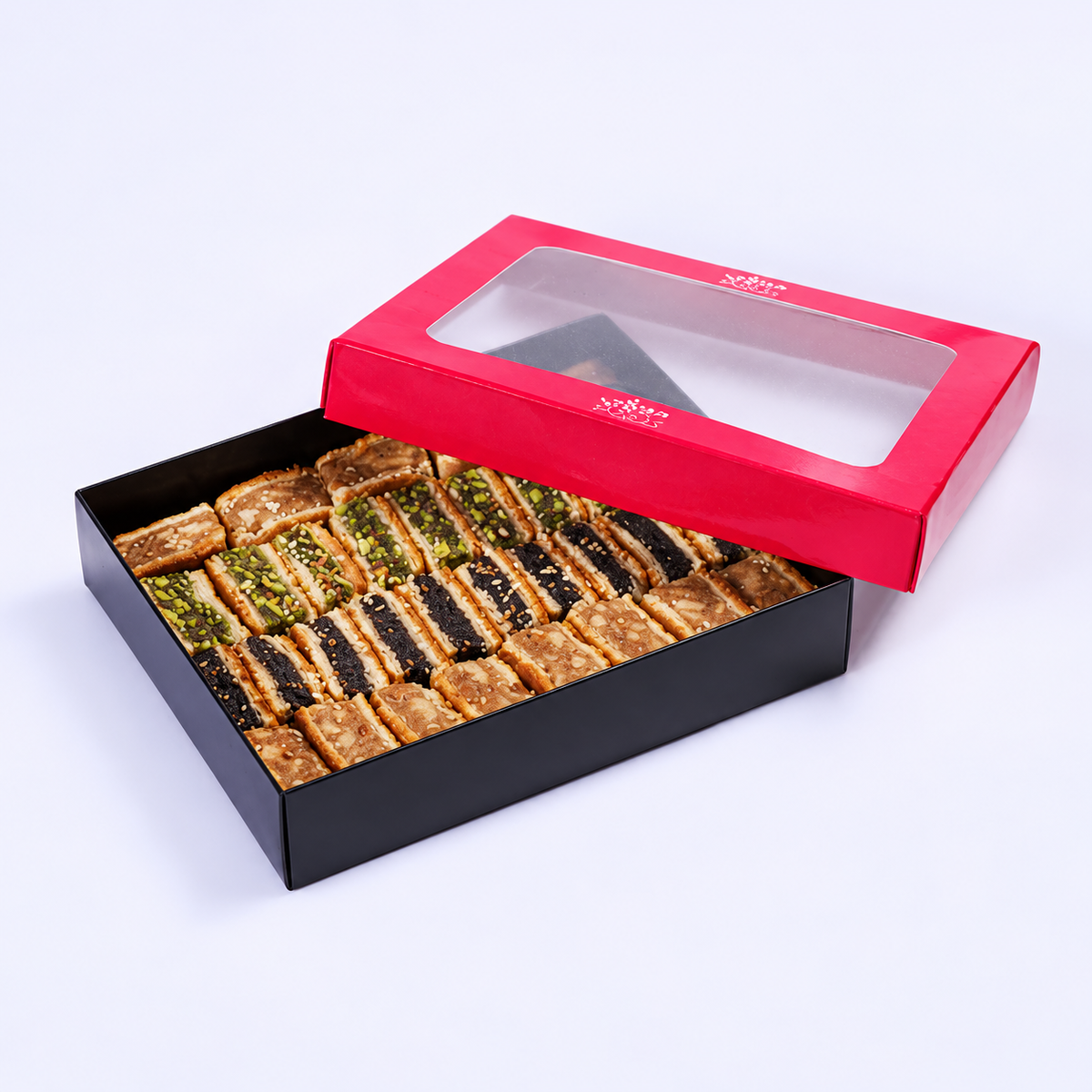 Douaihy Maamoul Mixed Flat ~ 30pcs. Mixed flat maamoul pastries in a black gift box with pink windowed lid.