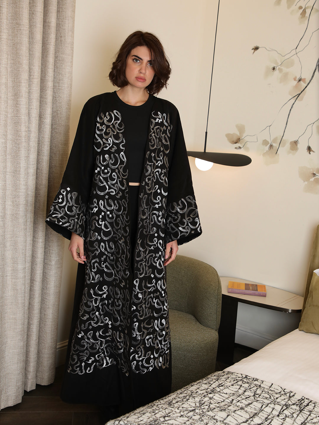 Black abaya with silver Arabic calligraphy embroidery by Mouftah El Chark, elegant modest wear for women at Idole Lebanon