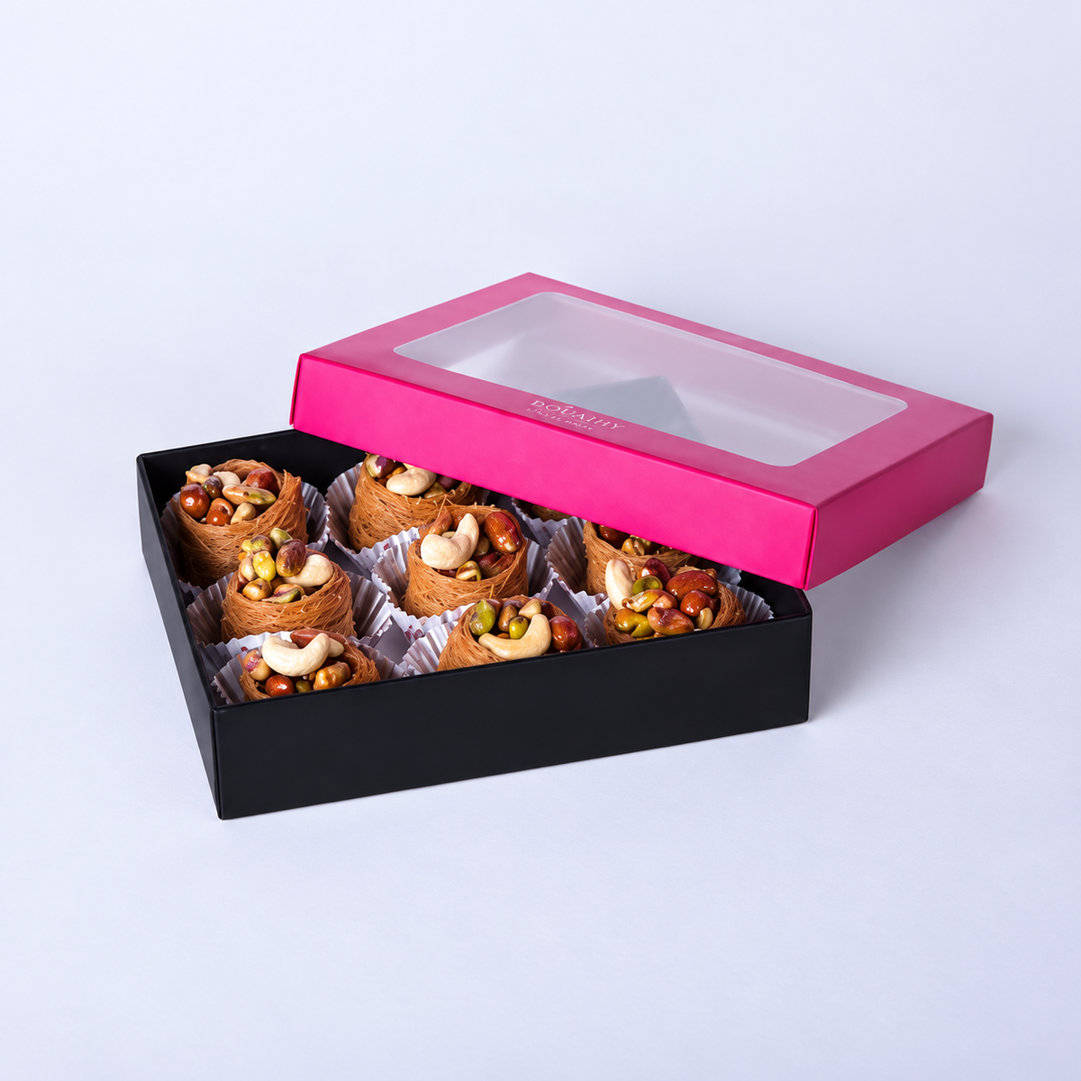 Douaihy Taj El Malak ~ 9pcs. Nut-filled pastry nests in a black gift box with pink windowed lid.