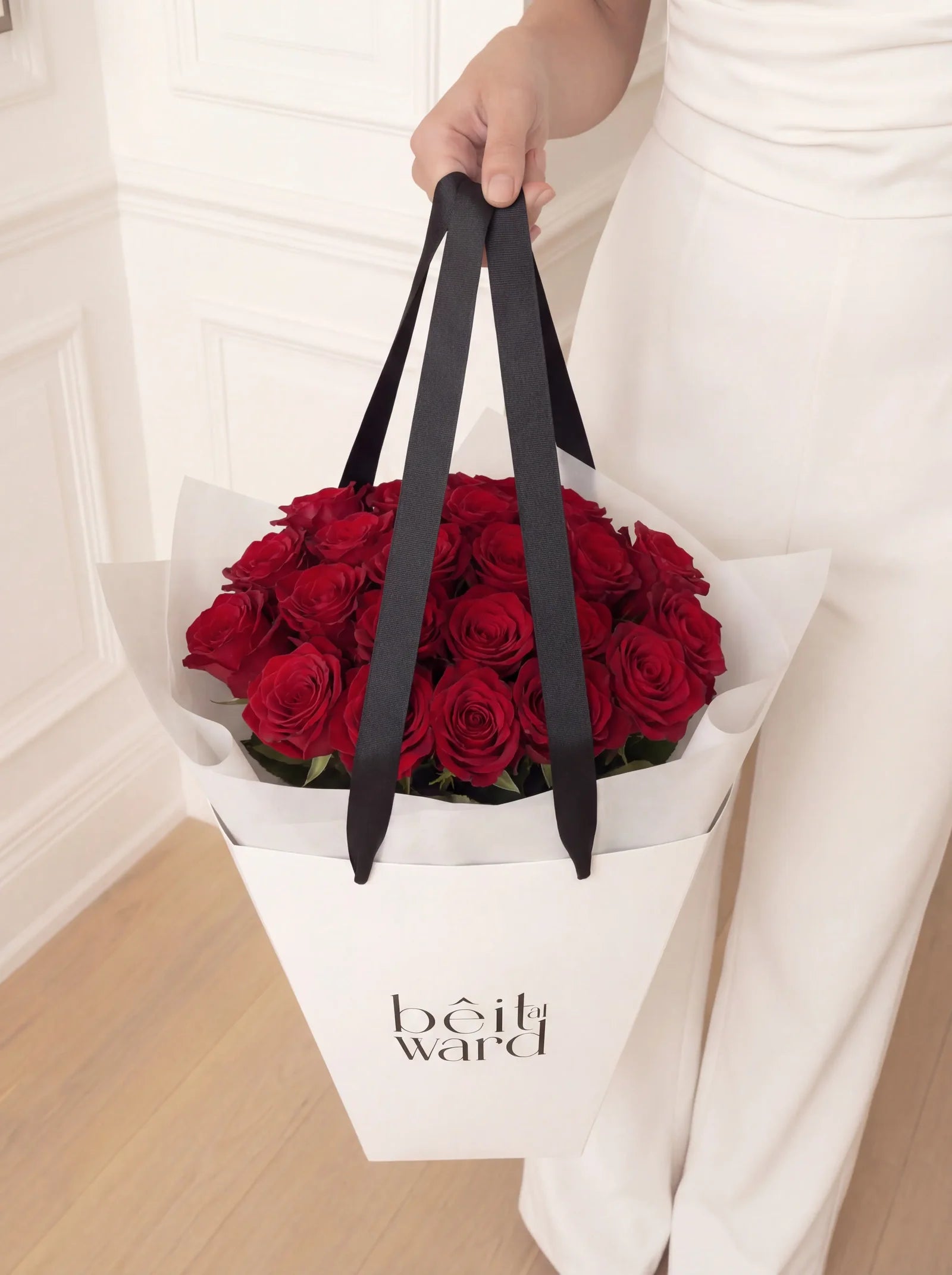 24 red roses arranged in white carry bag Lebanon by Beit El Ward