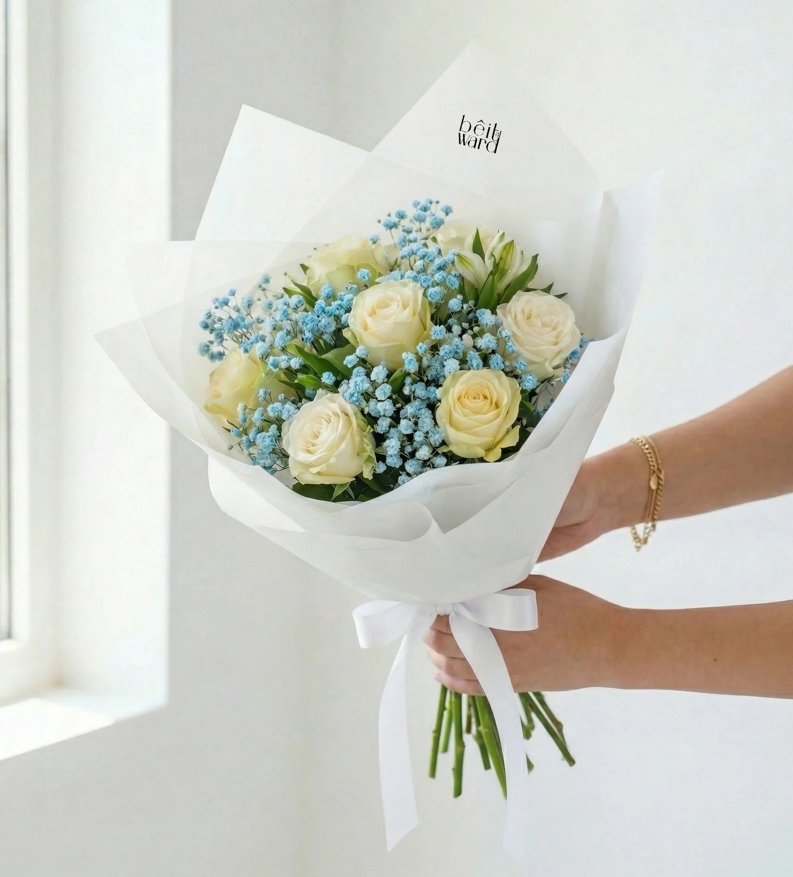 White rose bouquet with blue baby breath wrapped in white Lebanon by Beit El Ward