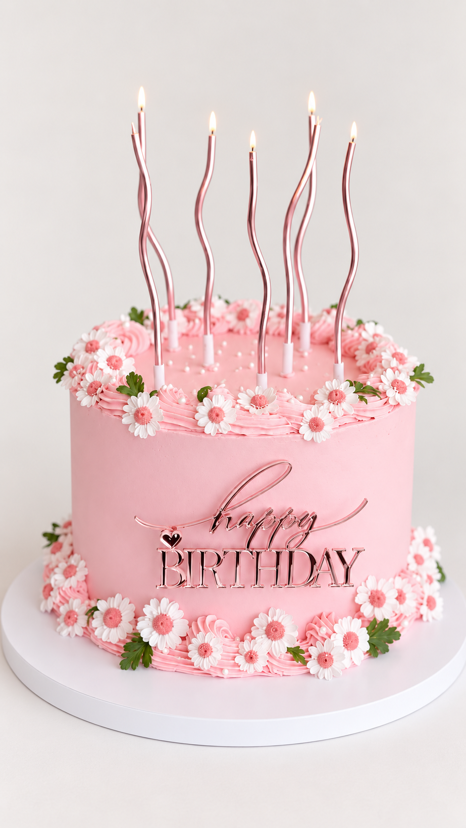 Pink daisy birthday cake with candles and Happy Birthday decoration