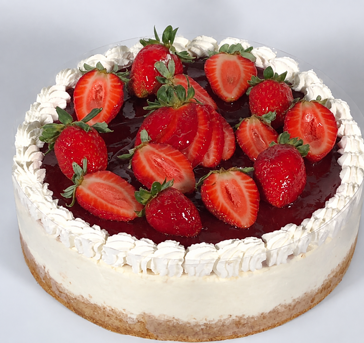 Fresh strawberry cream cheesecake with strawberries, whipped cream and biscuit base